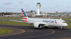Passenger boarding a transatlantic flight at an airport gate with New York skyline artwork